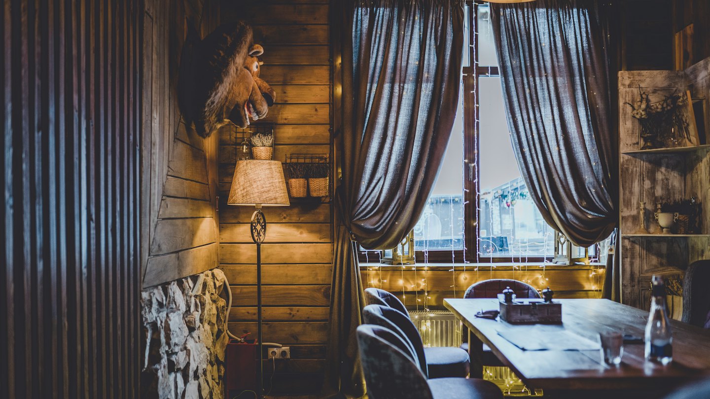 Acogedor comedor de restaurante con paredes de madera cálida e iluminación acogedora.