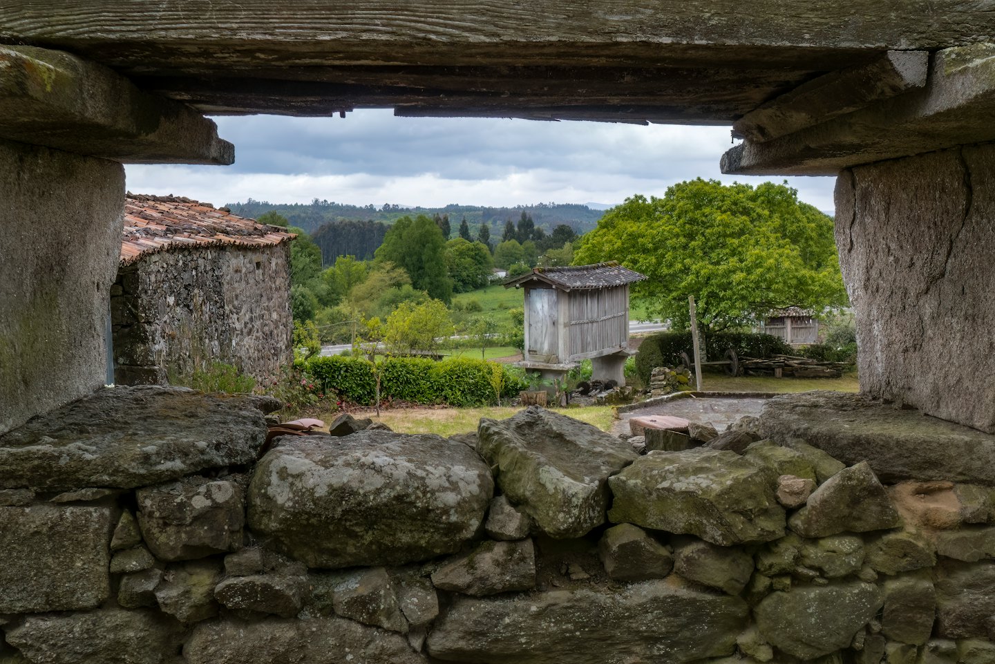 Edificios tradicionales de piedra con tejados de terracota en un paisaje rural.